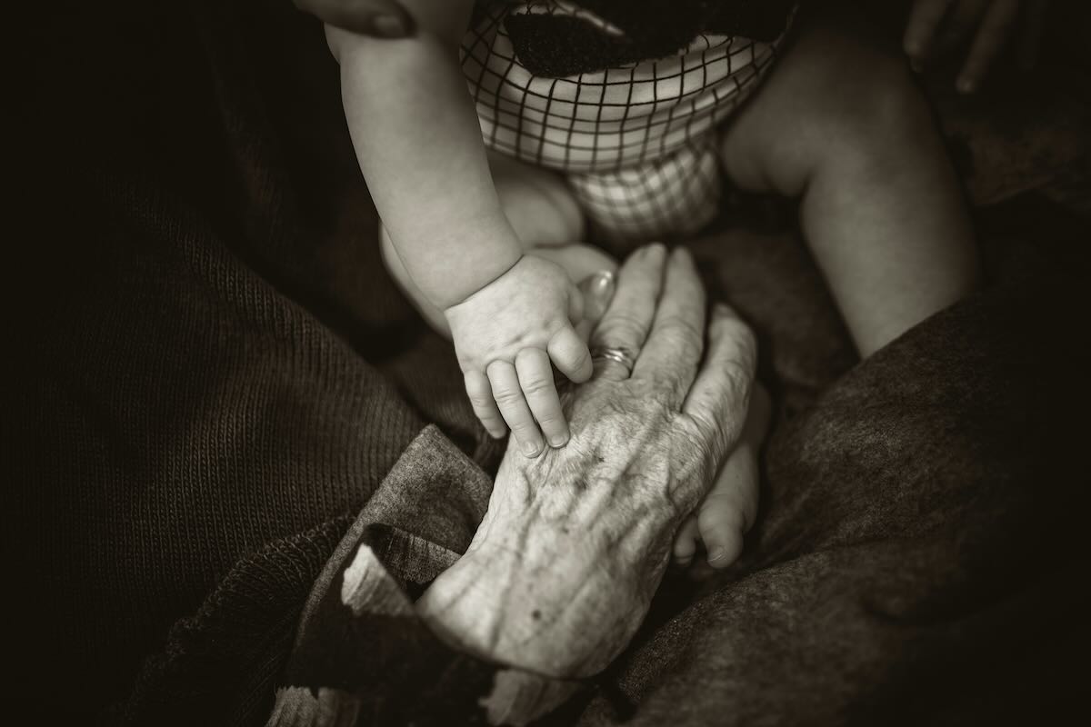 mani di un anziano e di un bambino